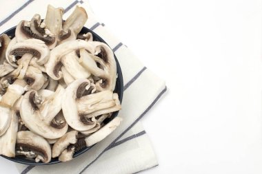 Tabakta dilimlenmiş taze mantarlar ve hafif bir havlunun üzerinde kayıt için boş alan var.