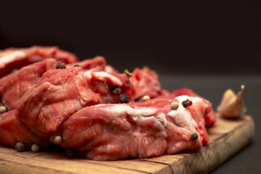 Tahta kesme tahtasının üzerine bezelye serpiştirilmiş çiğ mermer et.