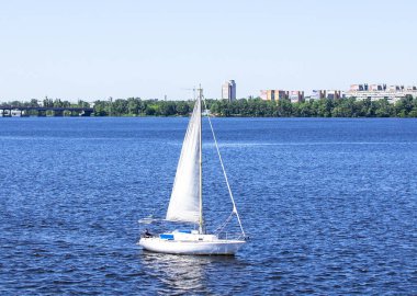 Şehirdeki nehirde beyaz yelkenli yelkenli..