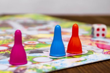 Çocuklar için mavi, turuncu ve kırmızı plastik zarlar ve masa oyunları.