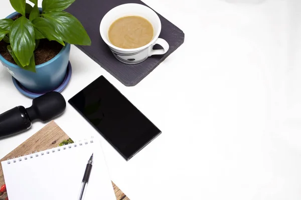 Self-satisfaction during work. On the desktop, coffee, flower, notebook, telophone, pen and vibrator.