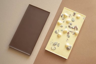 Kahverengi arka planda siyah beyaz çikolata çubukları. Yüzleşme ya da farklılık konularında kavramsal fotoğraf. Tersi siyah ve beyazdır..