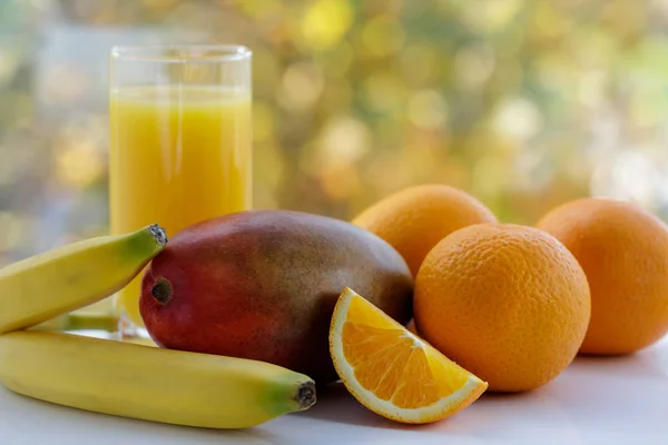 新鮮なオレンジ マンゴー バナナ ジュースが窓にあります 窓の外 — ストック写真