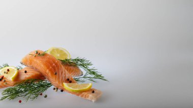 Açık gri tarafsız arkaplan ve metin için kopyalama alanı olan iki taze somon dilimi.