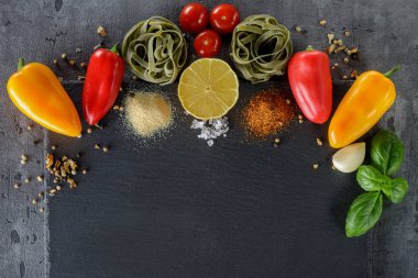 Makarna ıspanaklı fettuccine, çok renkli biber, domates, sarımsak, fesleğen, bir dilim limon ve baharat. Üst görünüm, kopyalama alanı ile