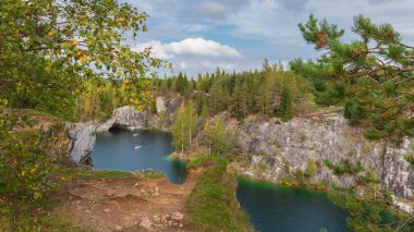 Bir sonbahar günü doğal bir parktaki mermer ocağının göz kamaştırıcı manzarası. Karelia, Rusya