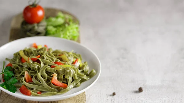 Masada baharat ve sebzeyle baharatlı ıspanaklı haşlanmış fettuccine. Seçici odak, kopyalama alanı olan arkaplan