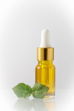 Hafif arka planda doğal nane özlü yağ içeren bir şişe yüz yağı serumu. Kopyalama alanı ile yakınlaş