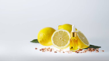 SPA kompozisyonu. Doğal limon esanslı bir yüz serumu ve hafif arka planda bir grup limon.