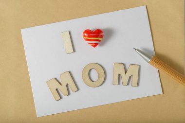 Anneler günü için içinde kalem ve mesaj olan bir tebrik kartı. Üst görünüm