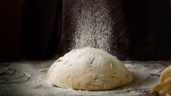 Bir somun ekmek için maya hamuru ya da un ile ahşap masada pişirilen diğer şeyler..