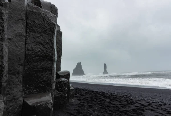 Stadt vik schwarzer Sandstrand schöne Felsformationen Berg — Stockfoto