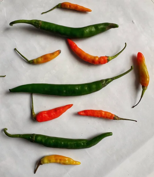Collection of red and green chillies on a white background. Great for settings, vegetable shops and more.