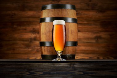 Bardak soğuk bira ve ahşap arka plan üzerinde eski varil