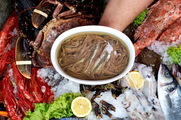 Vendedor presentando tazón de anchoa en tienda de pescado —  Fotos de Stock