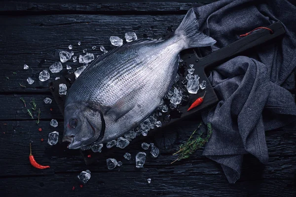 Färsk spansk braxen fisk (sargo) på isen på ett svart träbord — Stockfoto