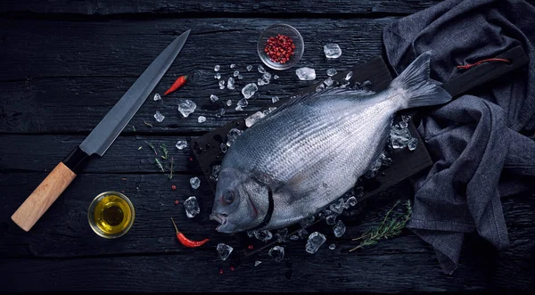 검은 나무 테이블에 얼음에 신선한 스페인어 도미 생선 (sargo) — 스톡 사진