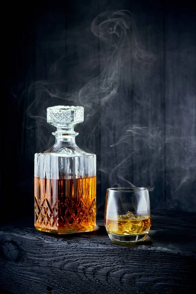 Sklenice whisky a karafa na černý dřevěný stůl — Stock fotografie