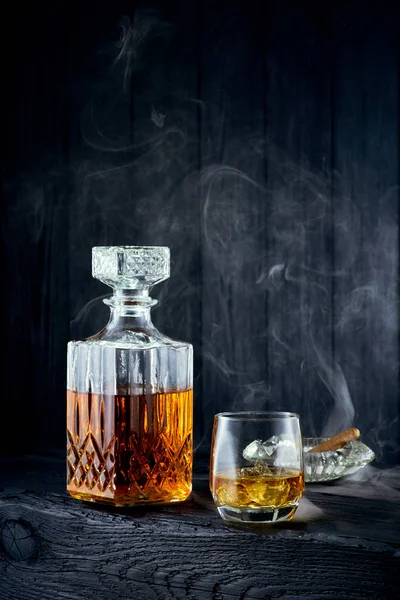 Glas whiskey en karaf op een zwarte houten tafel — Stockfoto