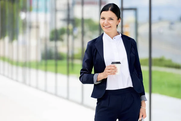 Portrait of self confidence business woman with coffee to go nex