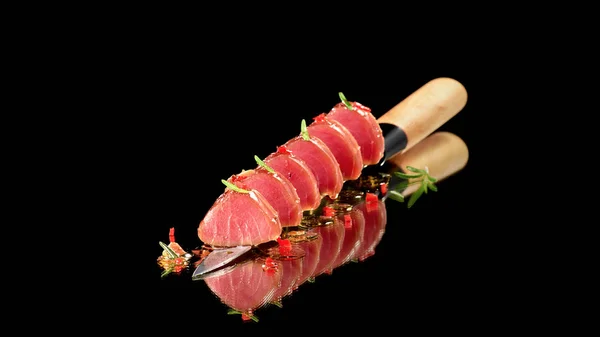 Стейк тунця в олії з чилі та розмарином, поданий на ножі — стокове фото