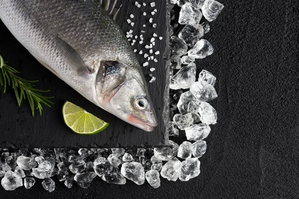 冰上的新鲜鲈鱼鱼在黑石桌上查看 — 图库照片