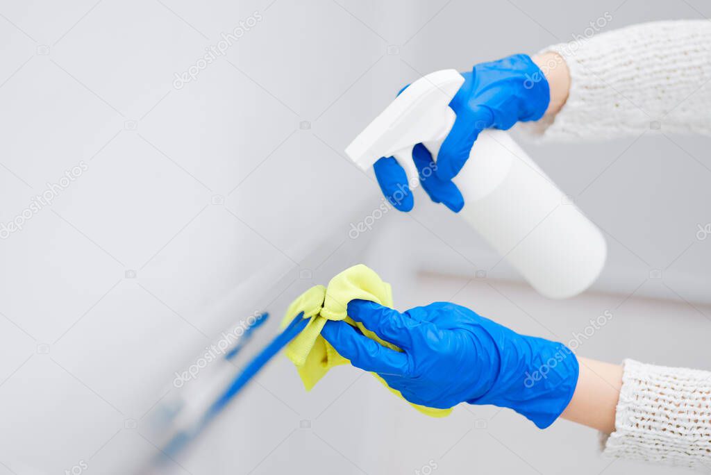 Close up hand of woman disinfecting handrail