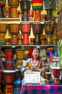 Eski Town Lijiang Yunnan Eyaleti, Çin'de yer almaktadır perakende djembe oynayan bir Çinli kız.