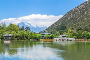 Landscape view of the Black Dragon Pool, it is a famous pond in the scenic Jade Spring Park located at the foot of Elephant Hill,Lijiang China. clipart