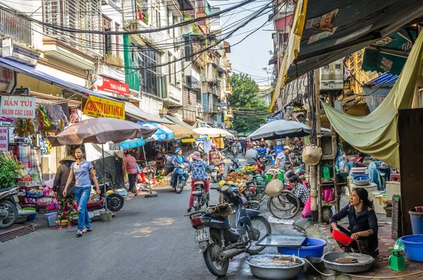 Drukke plaatselijke dagelijks leven van de ochtend straatmarkt in Hanoi, Vietnam. Een drukke menigte van verkopers en kopers in de markt. — Stockfoto
