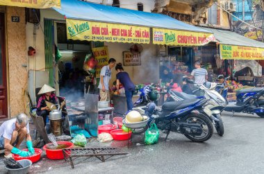 İnsanlar yiyecek ve müşteri Hanoi sokakta yanında onların yemek hazırlama görülebilir.