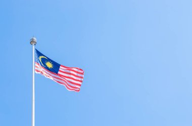 Malezya üzerinde sallayarak bayrak ile mavi gökyüzü Rüzgar.