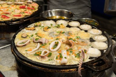 Ta Lay Krok (deniz ürünleri Takoyaki) Tayland 'ın en ünlü sokak yemeklerinden biridir, Ratchada Rot Fai Tren Marketi' nde satılır.