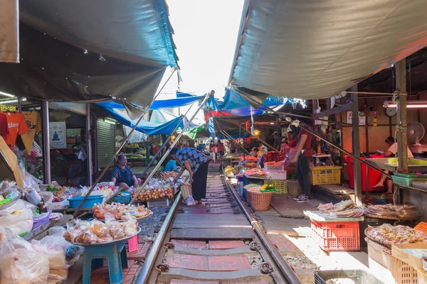 Los turistas pueden ver explorar y comprar a lo largo del Mercado Ferroviario de Maeklong . — Foto de Stock