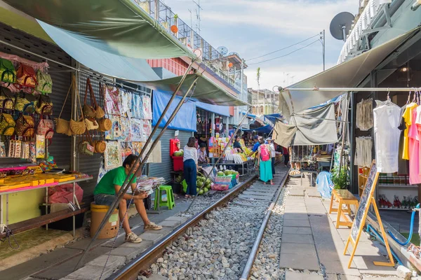 Los turistas pueden ver explorar y comprar a lo largo del Mercado Ferroviario de Maeklong . — Foto de Stock