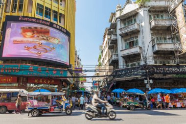 Yaowarat Yolu 'ndaki Chinatown Bangkok' ta sokak hayatı manzarası. İnsanlar market tezgahları, sokak kenarındaki restoranlar ve benzeri yerlerde keşifler yaparken görülebilir.