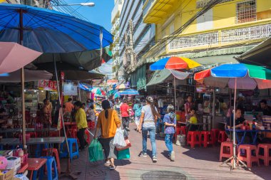 Yaowarat Yolu 'ndaki Chinatown Bangkok' ta sokak hayatı manzarası. İnsanlar market tezgahları, sokak kenarındaki restoranlar ve benzeri yerlerde keşifler yaparken görülebilir.