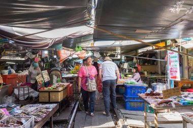 Maeklong, Tayland - 31 Ekim 2019: Turistler Maeklong Demiryolu Pazarı boyunca gezip alışveriş yapabilirler. Taze sebze, yiyecek, meyve ve giysi ve giysi satan bir Tayland pazarı..