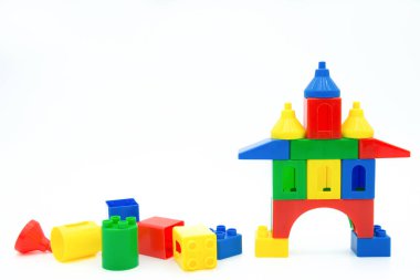Beyaz arkaplanda izole edilmiş renkli plastik yapı blokları.