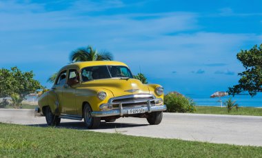 Havana, Küba - 12 Eylül 2016: Sarı güzel Amerikan Chevrolet Klasik Otomobil sürücü Havana Küba - Serie Küba 2016 röportaj kıyı yolu üzerindeki