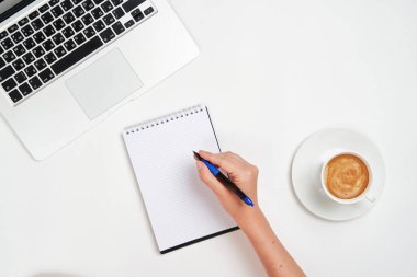 Not defterine kalem, klavye ve iş yerinde kahve yazan kişinin üst görünümü