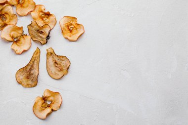 Ev yapımı organik kuru meyve cipsleri kağıt külahta ya da beyaz arka planda düz koni şeklinde poşet şeklinde dilimler.