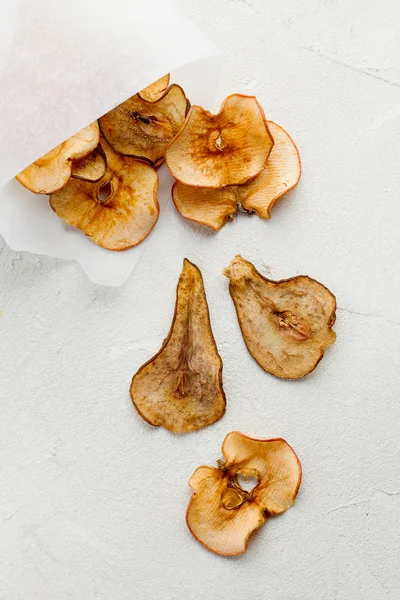 Органические домашние сухие фруктовые чипсы ломтики в бумажном конусе или мешок на белом фоне крупным планом . — стоковое фото