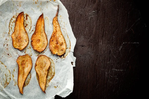 Batatas fritas de pêra desidratadas assadas com canela sobre papel manteiga — Fotografia de Stock