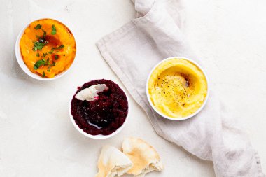 Bir çift vejetaryen Orta Doğu patlıcan, tatlı patates ve pancar soslu baba ganoush veya mutabba.