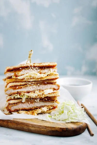 Katsu Sando japanese cutlet sandwich with deep fried pork,cabbage,mayonnaise and tonkatsu sauce on a light background