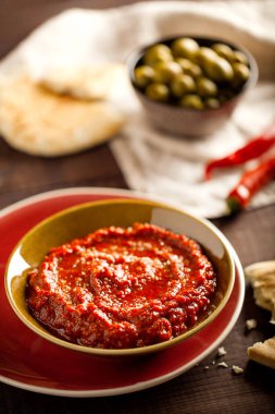 Geleneksel ev yapımı gül harissa-maghrebi kırmızı kırmızı biber ezmesi sarımsak ve zeytinyağıyla küçük kaselerde. Tunus ve Arap mutfağı adjika