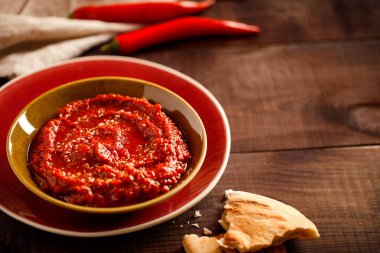 Geleneksel ev yapımı gül harissa-maghrebi kırmızı kırmızı biber ezmesi sarımsak ve zeytinyağıyla küçük kaselerde. Tunus ve Arap mutfağı adjika