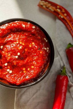 Geleneksel ev yapımı gül harissa-maghrebi kırmızı kırmızı biber ezmesi sarımsak ve zeytinyağıyla küçük kaselerde. Tunus ve Arap mutfağı adjika