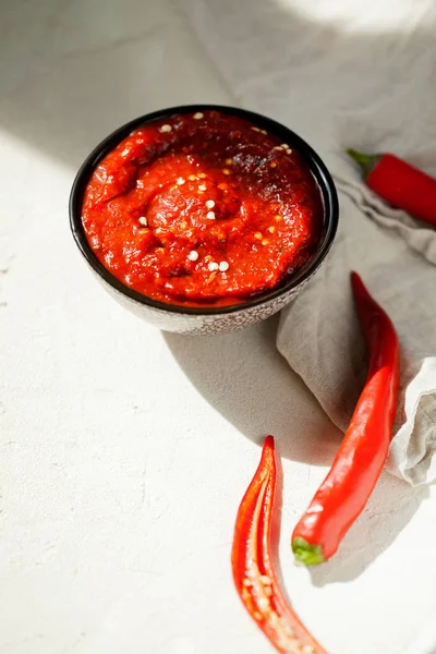 Tradisional buatan sendiri bangkit harissa-maghrebi cabai merah dengan pasta bawang putih dan minyak zaitun dalam mangkuk kecil. — Stok Foto